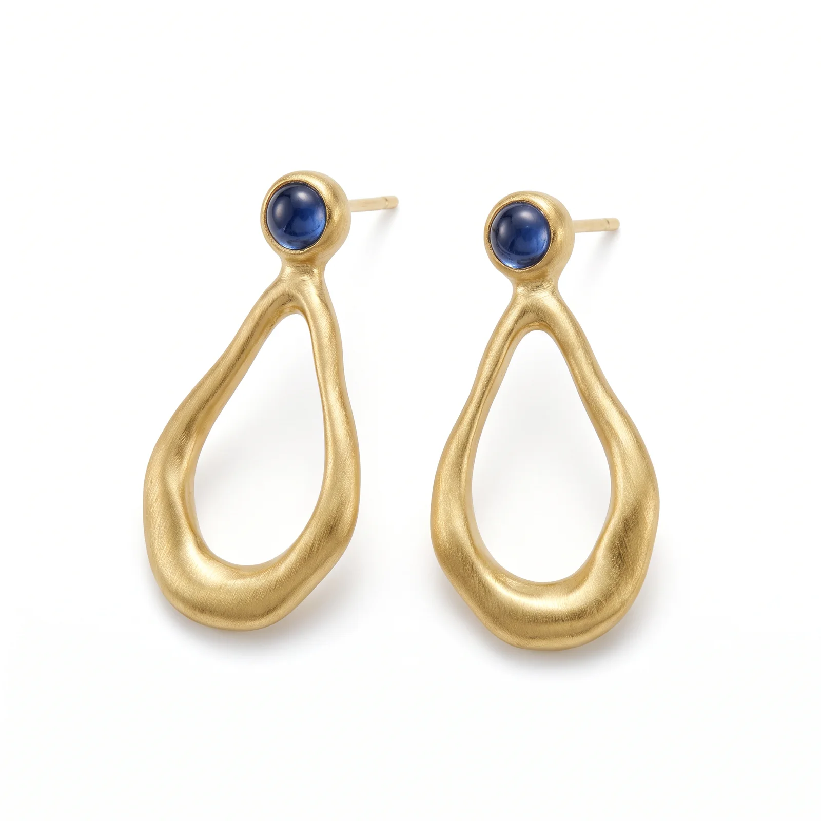 Boucles d'oreilles pendantes en or brossé et cabochons de saphir, sur fond blanc