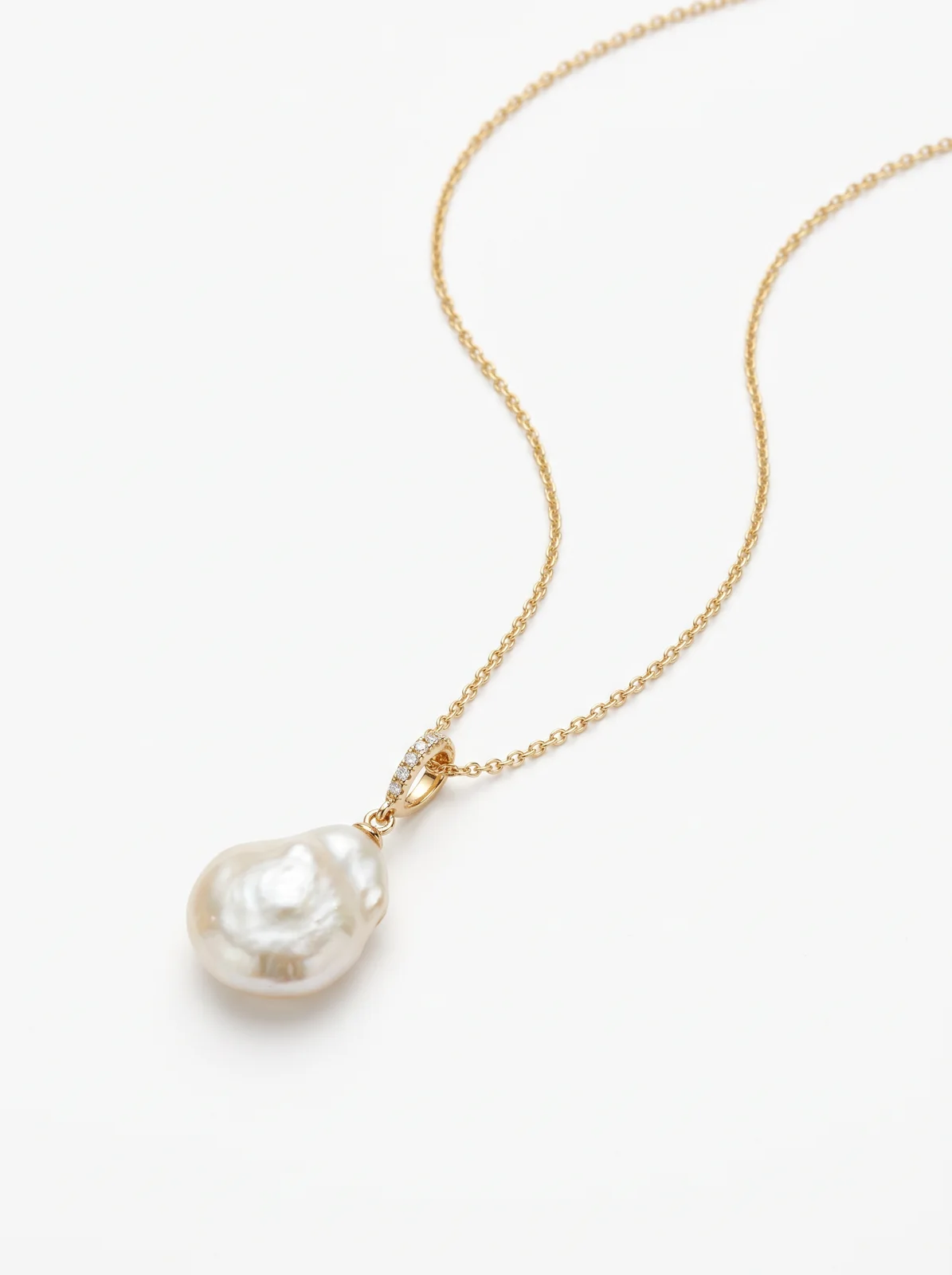 Collier chaîne en or avec pendentif perle baroque, sur fond blanc