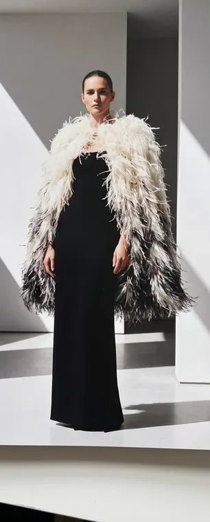 Cape longue en plumes ivoire et anthracite sur une robe fourreau noire